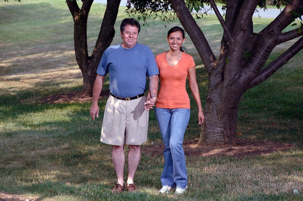 Older couple walking together in a green park
