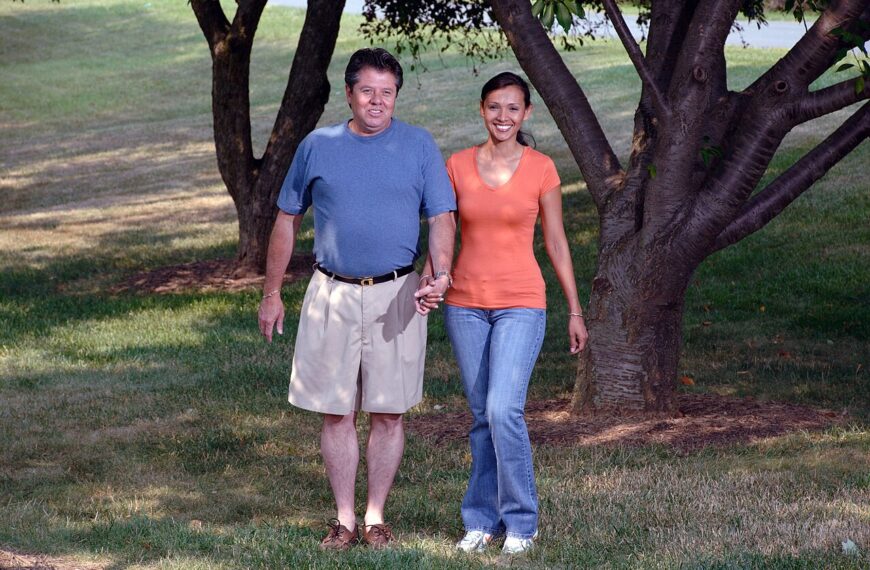 Older couple walking together in a green park